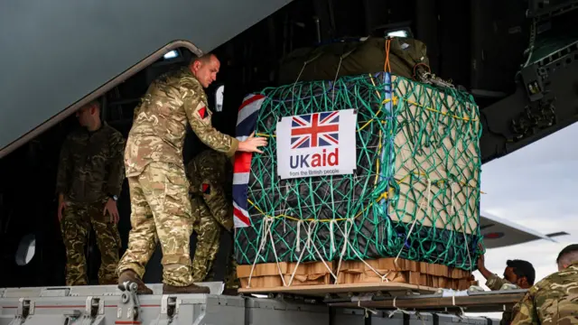 A member of 47 Air Despatch Squadron loads humanitarian aid onto an RAF aircraft to airdrop it along the northern coastline of Gaza