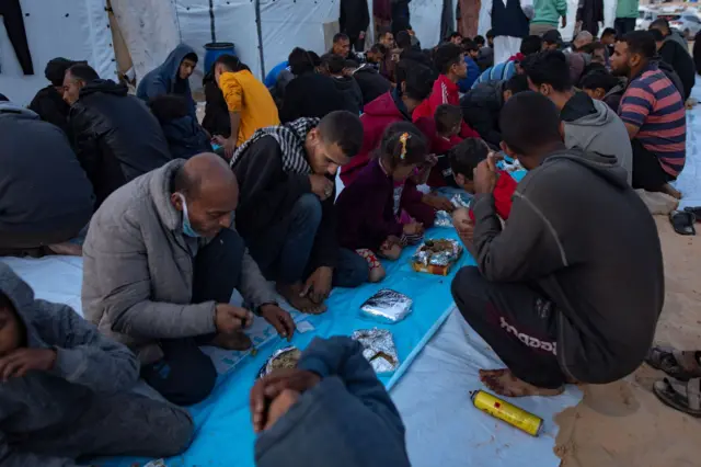 People praying and kneeling over food