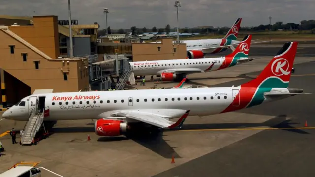 Kenya Airways planes are seen through a window as the Jomo Kenyatta international airport