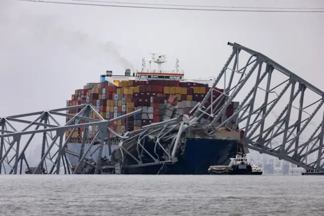 Parts of the Baltimore bridge lie on top of the Dali shipping container