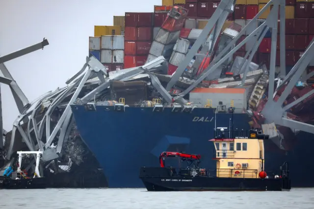 A US Army Corps of Engineers boat passes the wreckage of the Dali cargo vessel