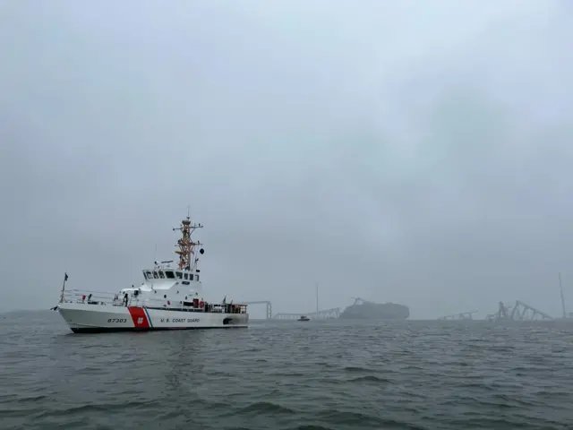 Grey waters and sky next to the ship and sunken bridge