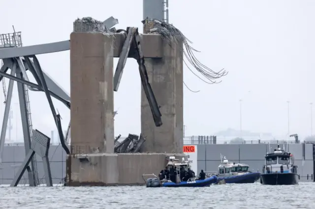 Emergency boats work near the collapsed section of the bridge