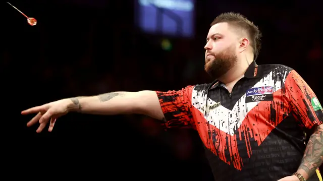 Michael Smith throws a dart