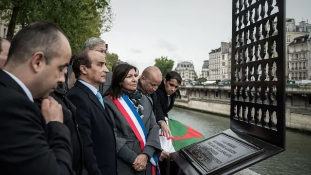 People standing around a plaque