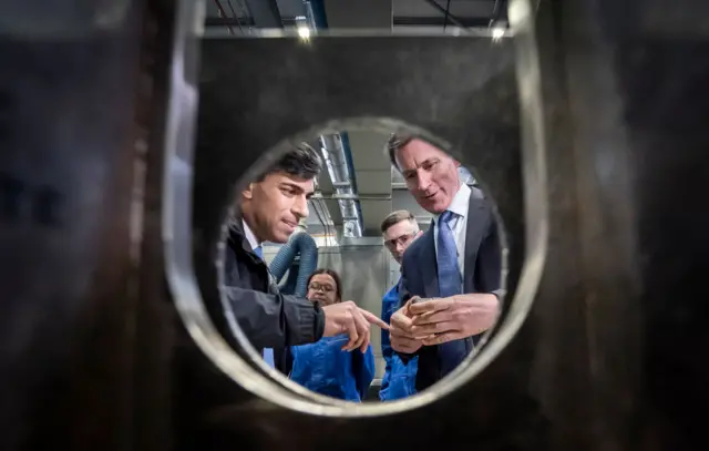 Rishi Sunak (L) and and Britain's Chancellor of the Exchequer Jeremy Hunt (R) during a visit to BAE Systems, Submarines Academy for Skills and Knowledge on March 25, 2024