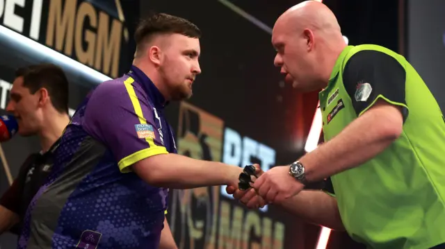 Luke Littler shakes hands with Michael van Gerwen