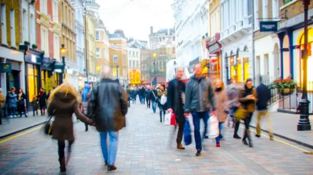 Shoppers on a UK High Street - stock image