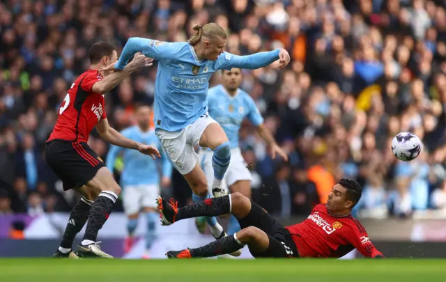 Erling Braut Haaland in action with Manchester United's Jonny Evans and Casemiro