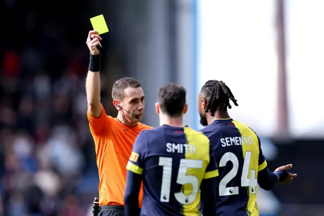 e David Coote shows a yellow card to Antoine Semenyo