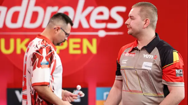 Dimitri Van den Bergh prepares to throw a dart