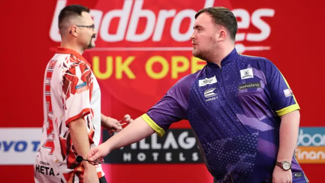 Luke Littler throws a dart