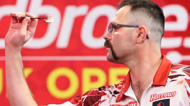 Damon Heta throws a dart