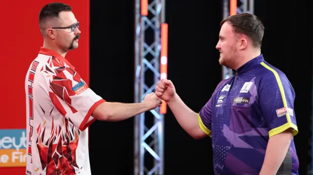 Damon Heta and Luke Littler shake hands