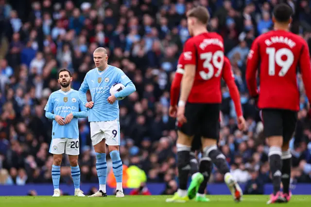 A dejected Erling Haaland and Bernardo Silva of Manchester City wait to restart