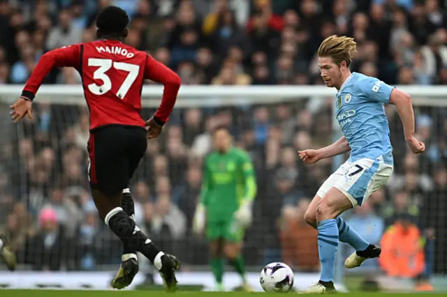 Kevin De Bruyne (R) passes the ball