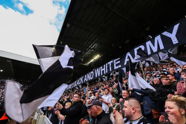 Newcadtle fans fly banners and flags with team players faces on before kick off