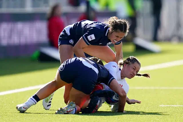 Emilie Boulard is tackled by two Scottish players