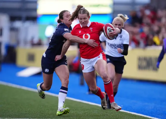 Wales Carys Cox hands off Scotlands Rhona Lloyd