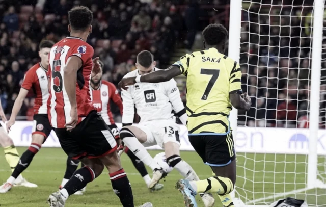 Saka lashes the ball across the goal face as Omar Bogle deflection puts it into the net