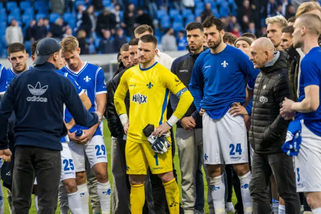 Darmstadt fan talking to players after defeat