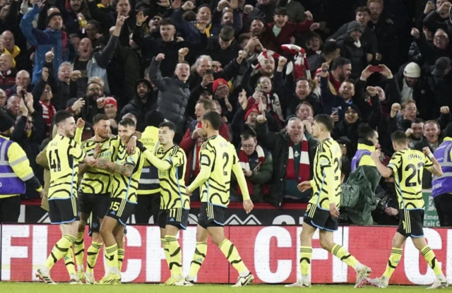 Arsenal players celebrate their sixth goal