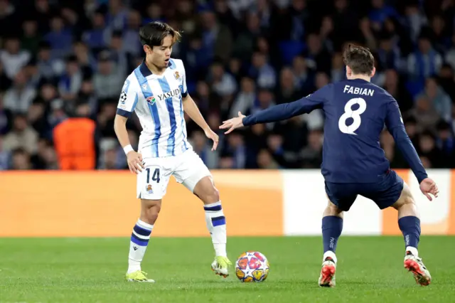 Kubo stands on the ball as he looks for a pass.