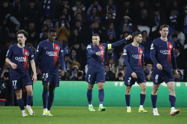 Mbappeis flanked by teammates as he celebrates his goal.