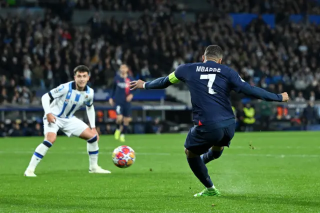 Mbappe shoots as a defender watches on.