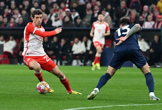 Muller tries to dribble past a Lazio player on the edge of the box.