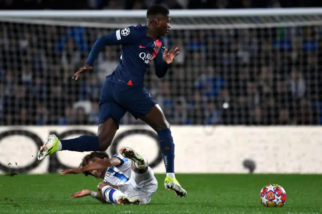 Mendes hurdles a Sociedad player in midfield.