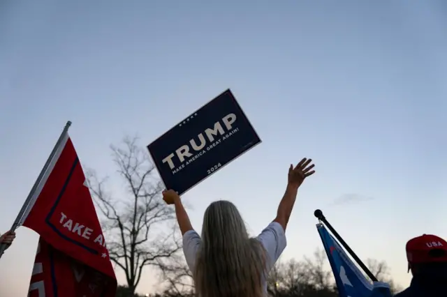 A supporter of former US President Donald Trump holds a sign outside a rally for Republican presidential candidate and former UN Ambassador Nikki Haley on January 24, 2024 in North Charleston, South Carolina.