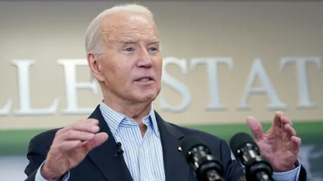 Biden gestures as he speaks into a microphone