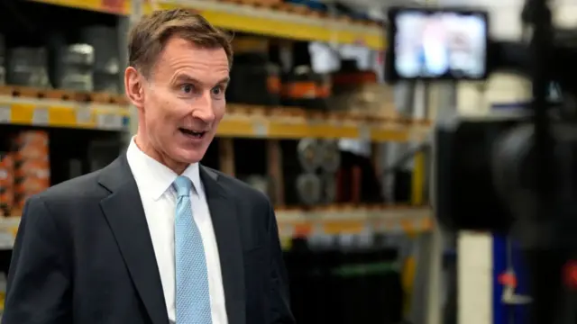 Jeremy Hunt speaks to a Tv reporter during a visit to a builders warehouse