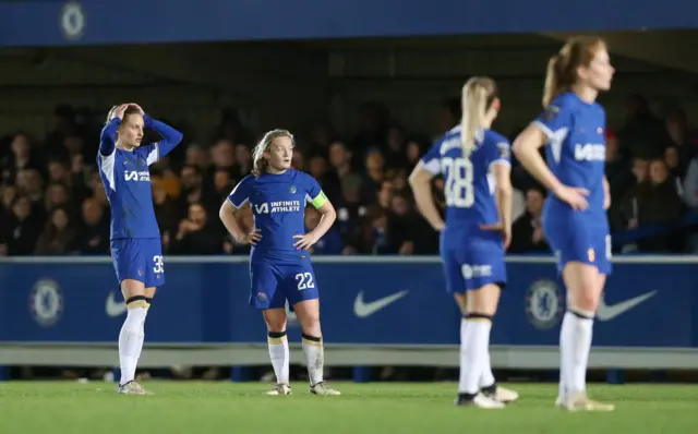 Chelsea players stand despondent after their huge loss to Man City.