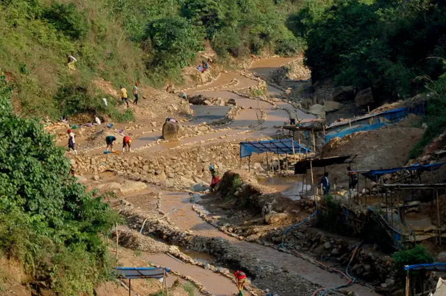 Workers, including women and children, work in a cobalt mine through small-scale and non-corporate mining activities referred to as "artisanal" mining, carried out under very poor conditions,