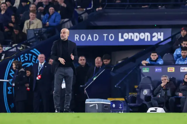 Pep Guardiola stands on the touchline