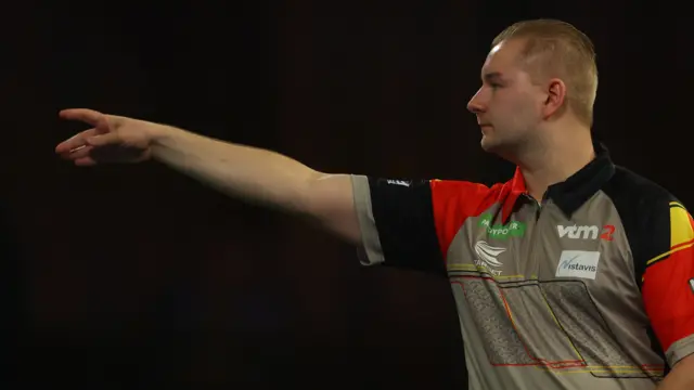 Dimitri van den Bergh throws a dart