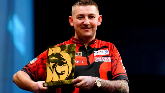 Nathan Aspinall holds the Premier League night five trophy