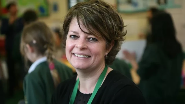 A smiling picture of Ruth Perry with a green lanyard around her neck