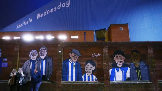 Sheffield Wednesday fans in front of mural