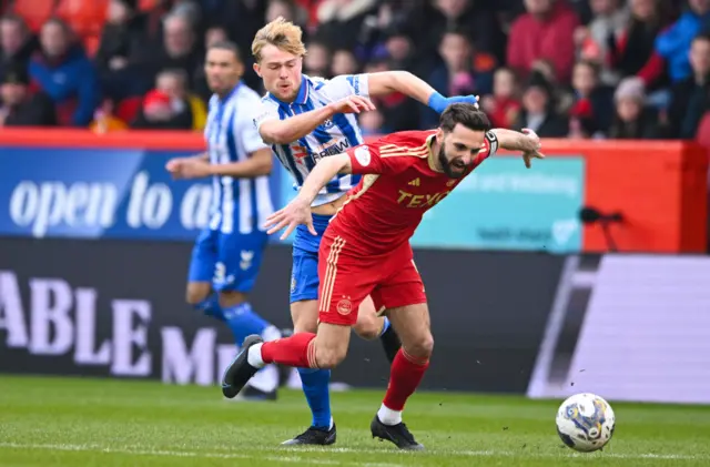 Aberdeen's Graeme Shinnie is tackled by Kilmarnock's David Watson during a Scottish Cup Quarter Final match between Aberdeen and Kilmarnock at Pittodrie Stadium, on March 09, 2024, in Aberdeen, Scotland.