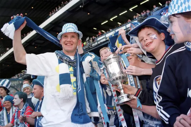 Kilmarnock captain Ray Montgomerie celebrates with Kilmarnock supporters after lifting the Scottish Cup