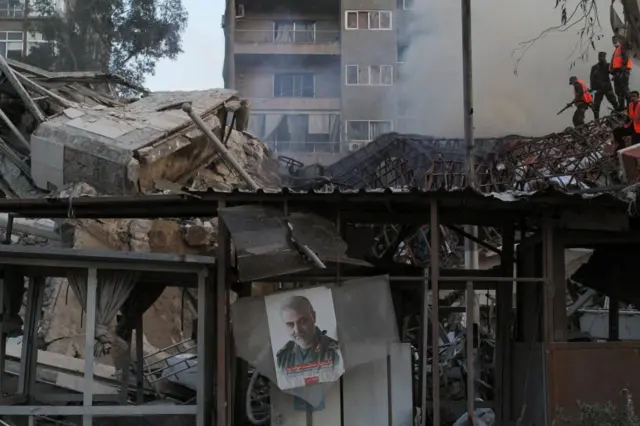 A picture of late senior Iranian military commander General Qassem Soleimani hangs amid rubble