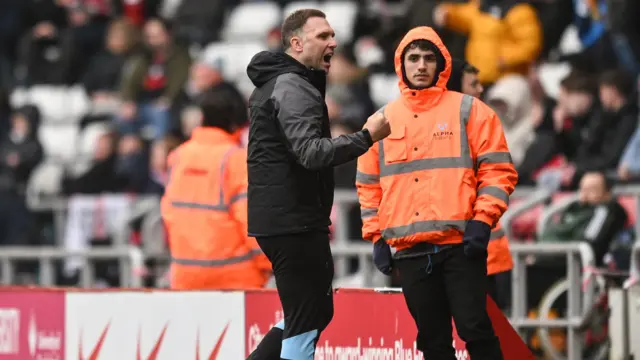 John Eustace clenches his fist on the touchline