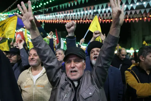 People carrying Iranian and Palestinian flags protest