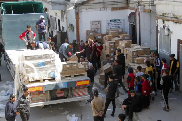 People unload medical aid from a truck, near Kamal Adwan Hospital in the northern Gaza Strip