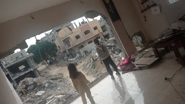 Elham's children look out from the remnants of their house in Rafah