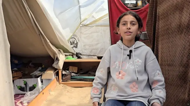 Sarah Amer, 11, sits in a makeshift tent