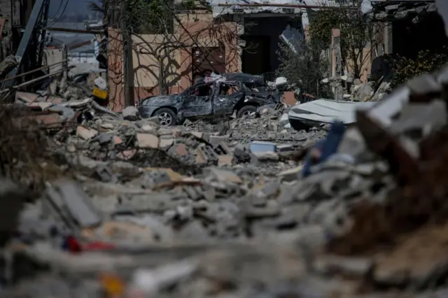 Rubble and a burned out car in Khan Younis